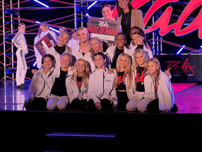 a group of people standing in front of a crowd posing for the camera